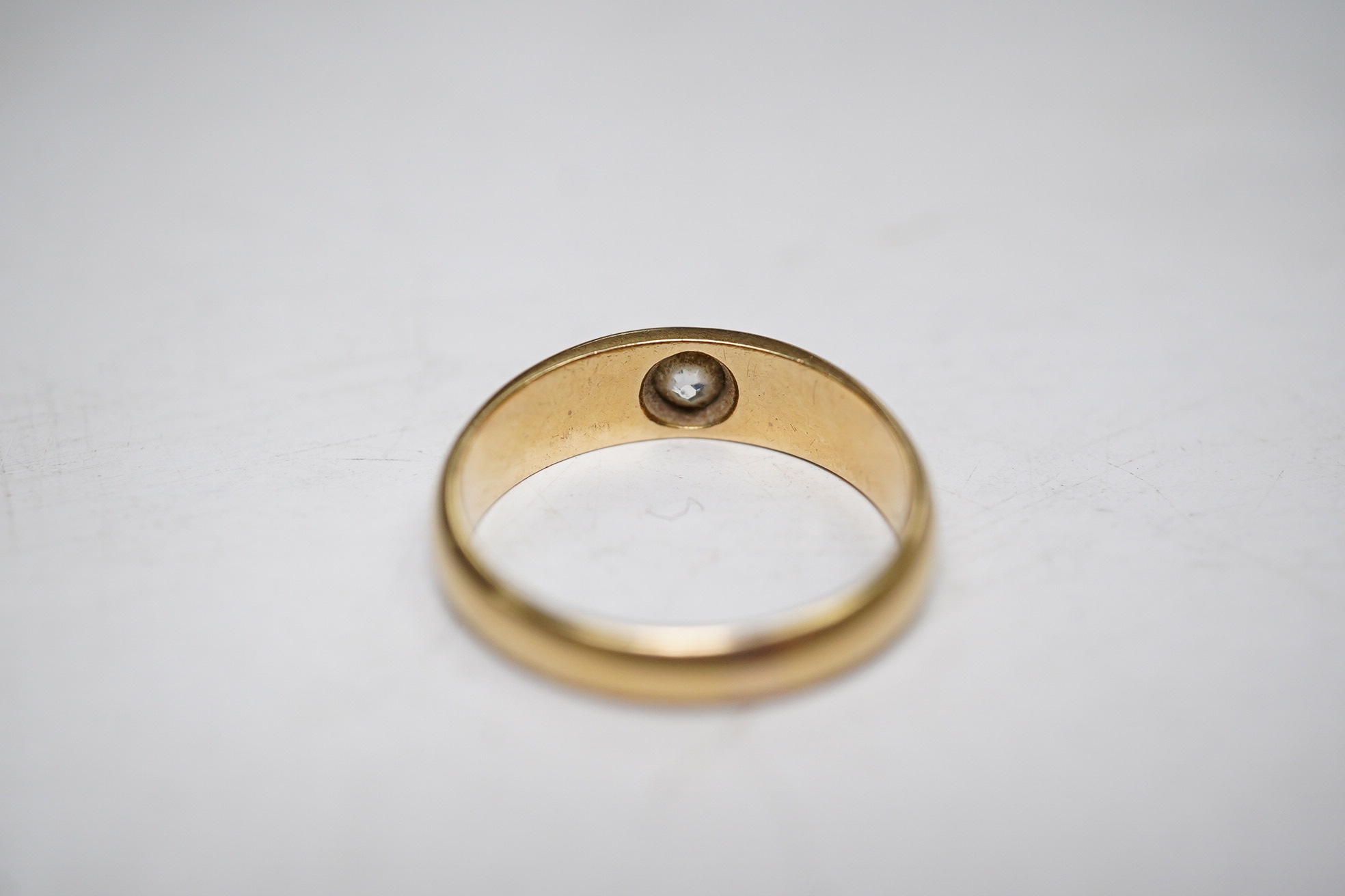 A late Victorian 18ct gold and single stone gypsy set diamond ring, size P, gross weight 5.3 grams. Condition - fair